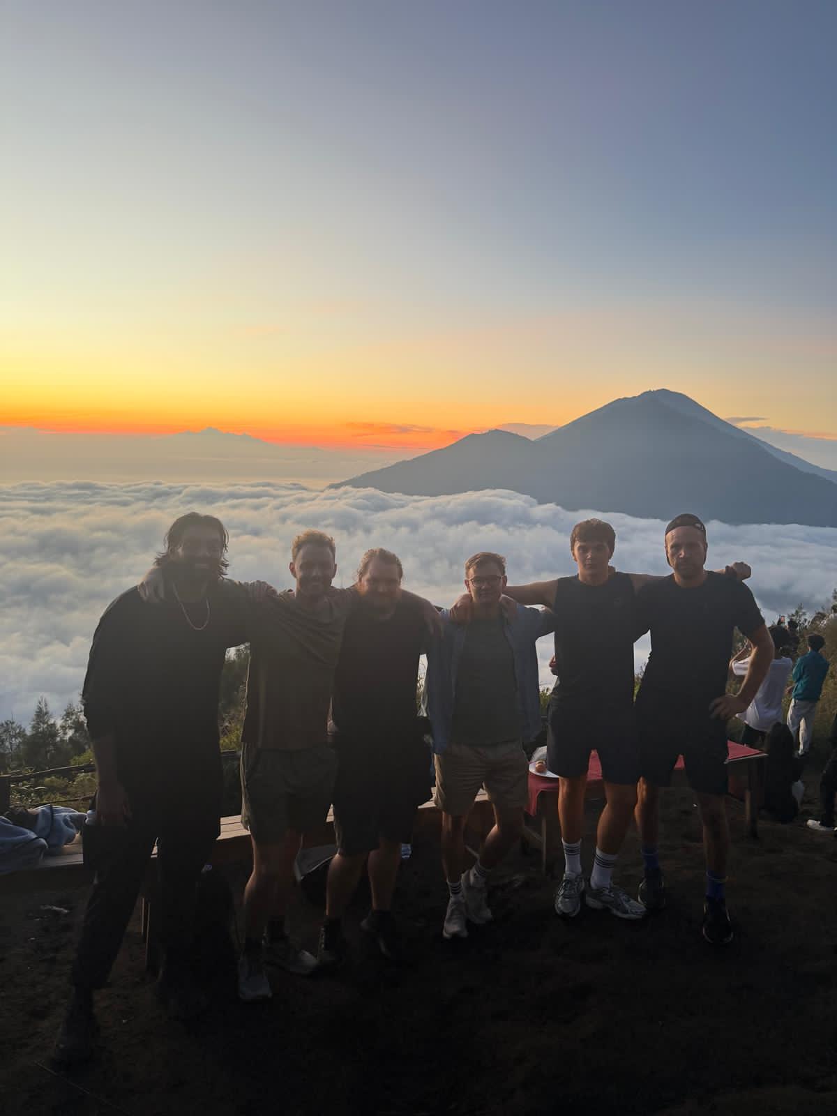 Small group of international travelers at Mount Batur summit